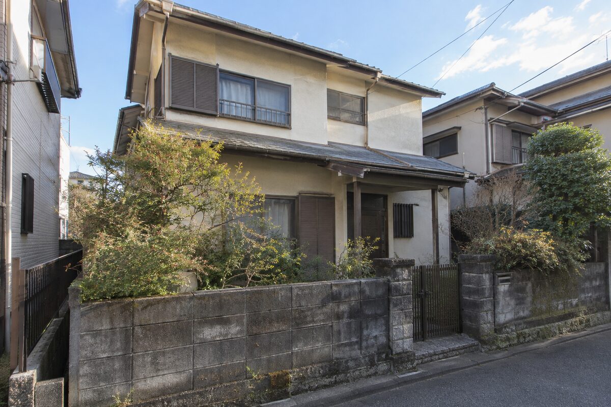 借地に建つ築年数の経った木造2階建て一戸建ての外観